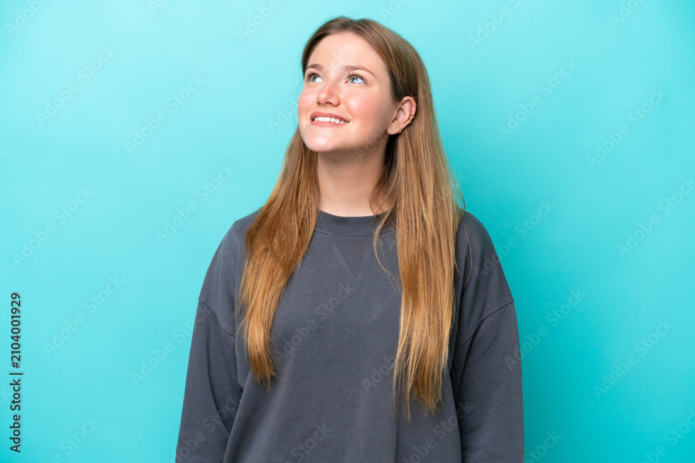 Fototapeta premium Young caucasian woman isolated on blue background thinking an idea while looking up