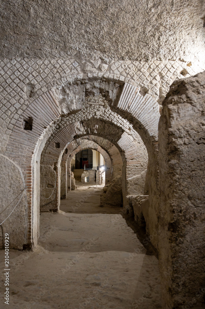 Obraz premium Naples, italy. December 29, 2024. Naples subterranean archaeological pathways with historic roman arches and stone walls, a journey into ancient history and architecture