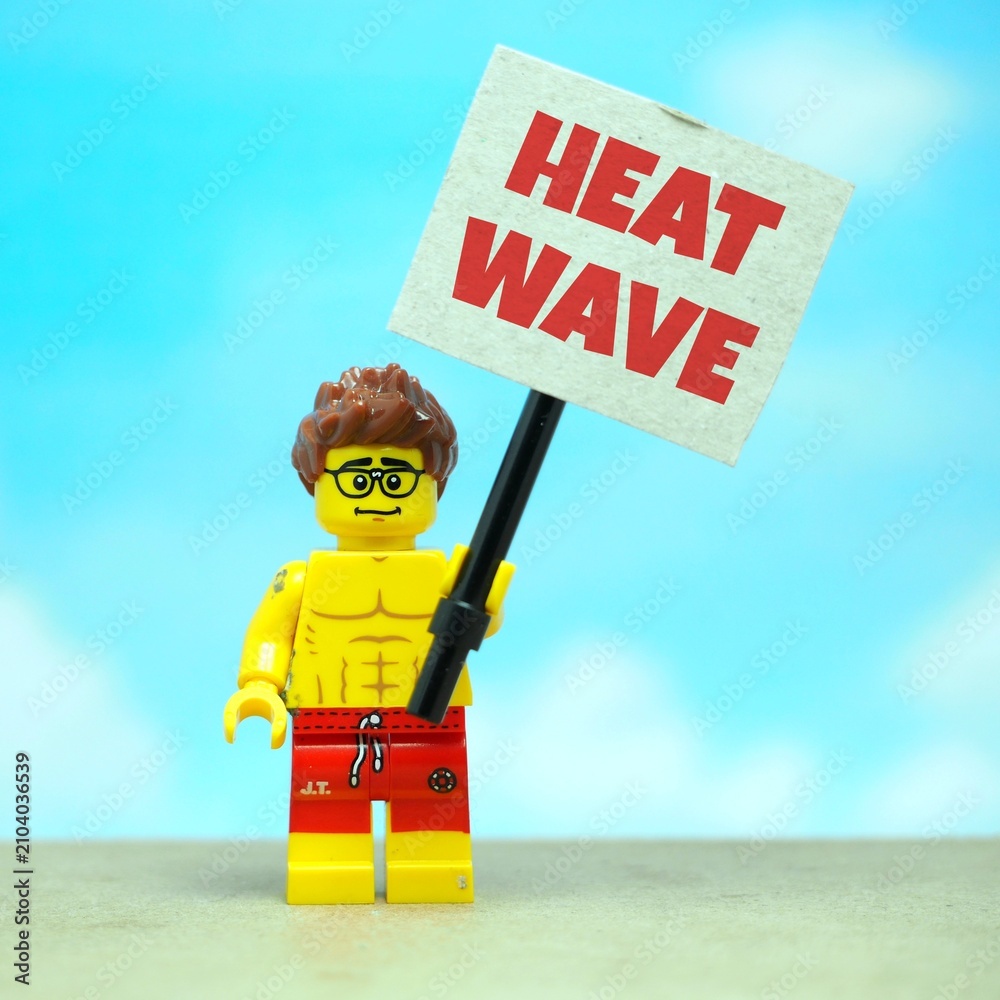 Fototapeta premium Indonesia - July 12, 2026 : Mini toy of action figure at outdoor with blur background. Miniature photography concept design. Minifigure of man male people hold 50° Celcius text at poster banner.