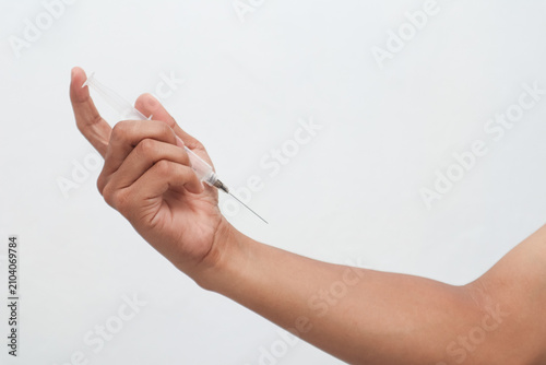 Fotografie Hand Holding Syringe with Needle Against White Background