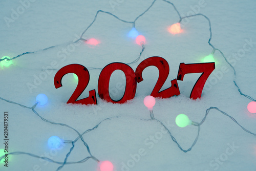 Happy New Year 2027 Wooden Numbers in Snow with Festive Lights