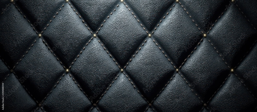 Obraz premium Close-up of black, textured leather with diamond pattern and gold-colored embellishments