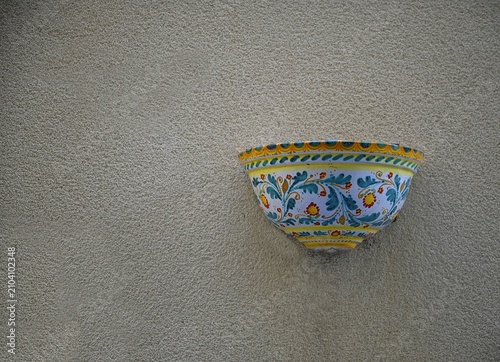 Bild auf Leinwand Antique handmade Sicilian Caltagirone half moon ceramic planter on a textured wall in Sciacca Sicily, Italy
