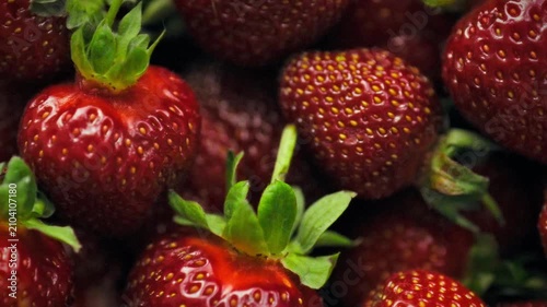 A close-up of ripe red strawberries with green leaves in a volumetric frame with soft light. The detailed texture of the grains creates a rich, natural background. A berry harvesting concept
