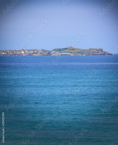 Foto A distant headland and town from across a bay of water.