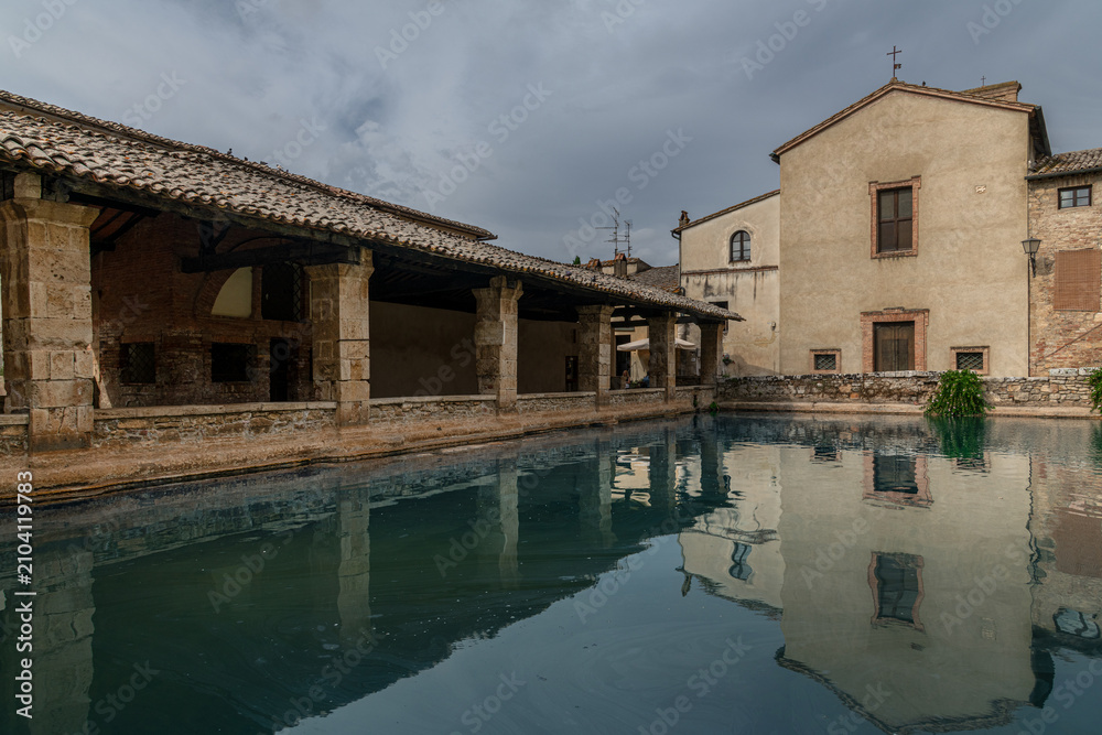 Obraz premium The Piazza delle Sorgenti, the central square with an ancient thermal pool in Bagno Vignoni, Italy