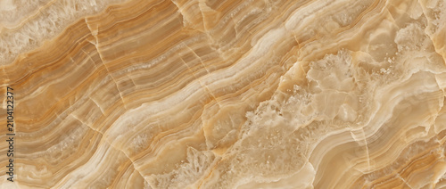 Fotografie Golden onyx surface featuring layered natural bands with warm amber tones and a