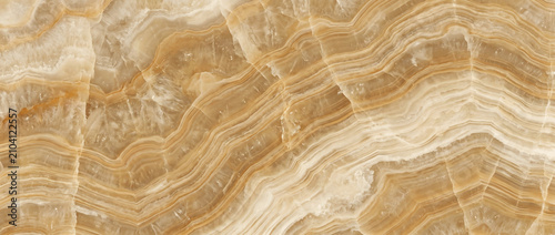 Foto Amber onyx surface featuring layered natural bands with warm honey tones and a s
