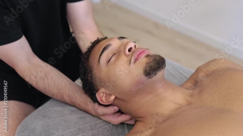 Professional physical therapist massaging man's neck
