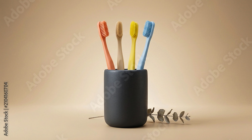 Four Colorful Eco Friendly Toothbrushes in Dark Ceramic Holder on Bathroom Countertop
