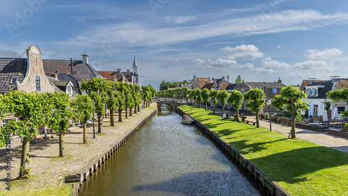 Foto Historic canal scene with boats and church spire in Sloten, Friesland, Netherlan
