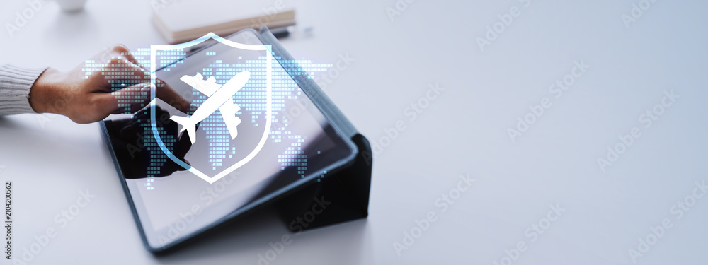 Obraz premium Woman using tablet with airplane and shield hologram over dotted world map on light banner with copy space showing travel insurance and safe flight booking.