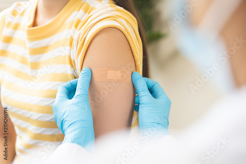 Vaccination coronavirus, hand of doctor apply plaster, bandage after doctor giving vaccine, injection dose on arm patient, immunization disease prevention against flu pandemic influenza, health care.