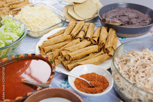 flautas de pollo or chicken fried tacos in Mexico Latin America, Mexican feast with Homemade food on table