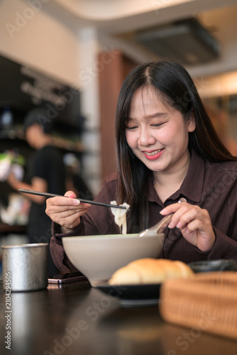 Vertical Portrait of a Smiling Asian Woman Having a Noodle Meal