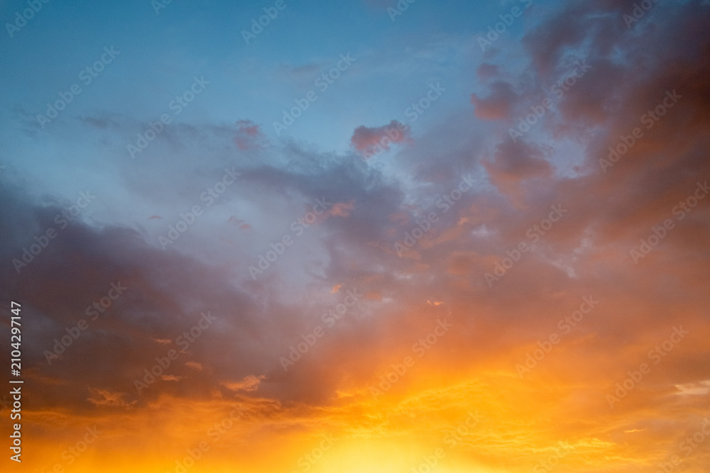 Fototapeta premium Dramatic Orange and Blue Sunset Sky with Clouds