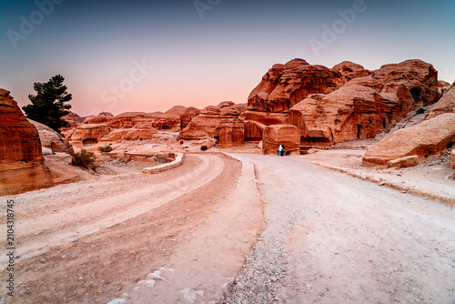 Tableau sur toile Tourist on the road leading to rock city Petra in Jordan, Wadi Musa