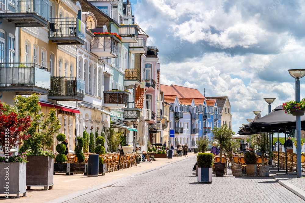 Obraz premium Historic waterfront promenade in Sonderborg featuring restaurants, outdoor cafés, colorful facades and a relaxed summer atmosphere along Flensburg Fjord.