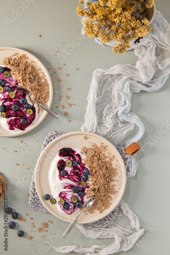 Top Down Flat Lay of Yogurt Bowls with Blueberry Swirl and Whole Grain Flakes