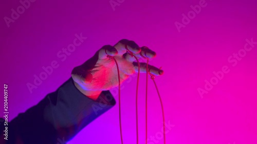 Hand with Puppet Strings in Neon Pink Light — Control and Manipulation Concept
