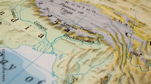 gliding view over tibet, ganges and brahmaputra on printed atlas map