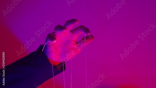 Hand with Puppet Strings in Neon Pink Light — Control and Manipulation Concept