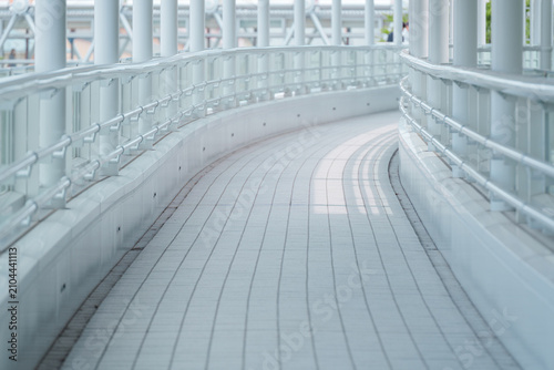 Fotografía 白い柱とガラスの手すりが並ぶ歩行者通路。公共建築やバリアフリーの背景