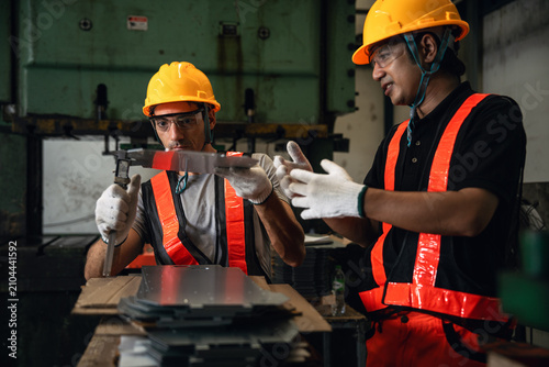 Obraz na plátně Quality Inspectors Measuring a Manufactured Metal Component with a Caliper Besid