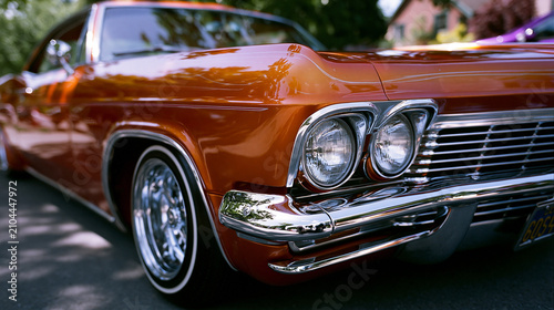 Oranger Lowrider mit Chromfelgen glänzt in der Sonne