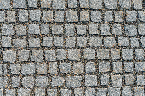 Bild auf Leinwand Granite sett paving with gravel joints, gray square stone cobblestone texture ba