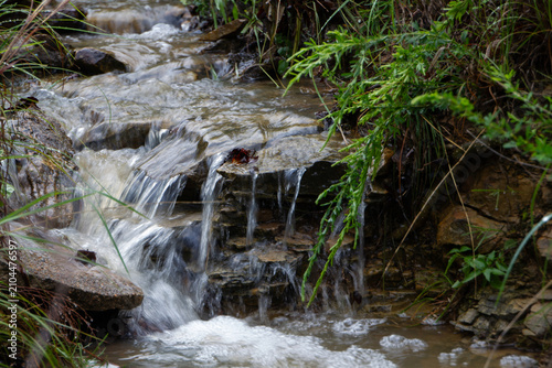 Water streams down the rocky mountain terrain after the rain