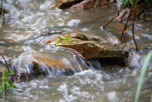 Water streams down the rocky mountain terrain after the rain