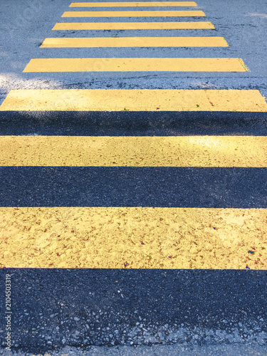 Pedestrian crossing with yellow stripes on asphalt. Special road signage. Road markings warning of temporary roadworks or changes. Caution and road safety.