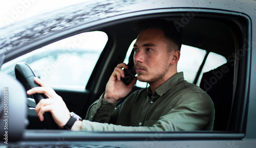 Man sitting in his car and calls with mobile