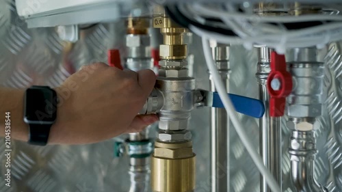 HVAC Technician Adjusting Heat Pump and Boiler System in Modern Mechanical Room