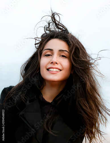 Canvastavla Portrait de jeune femme souriante aux longs cheveux bruns balayés par le vent