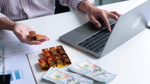 Wealthy businessman managing a physical portfolio of gold bullion and US dollars for inflation hedge.