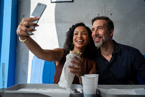 Konstfotografi Happy couple taking selfie with smart mobile phone at tortilla restaurant - Youn