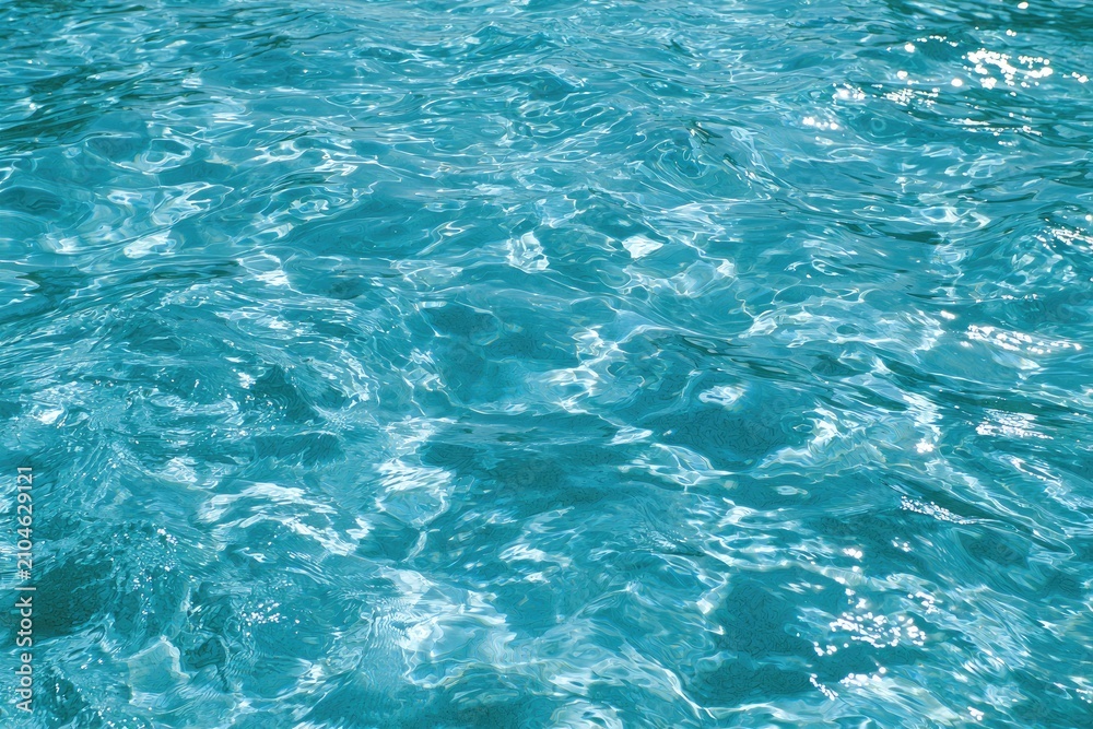 Fototapeta premium Shimmering turquoise water surface, sparkling with light reflections