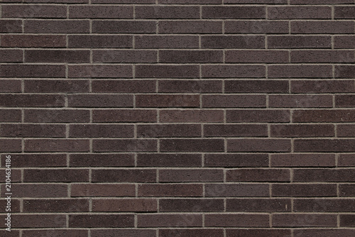 фотографія Dark brown brick wall texture with horizontal brick pattern.