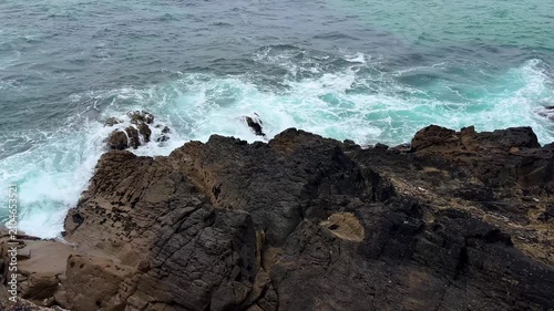 rocky coastline with waves crashing against rocks, natural scene from above the rocky shore perspective, travel and nature concept