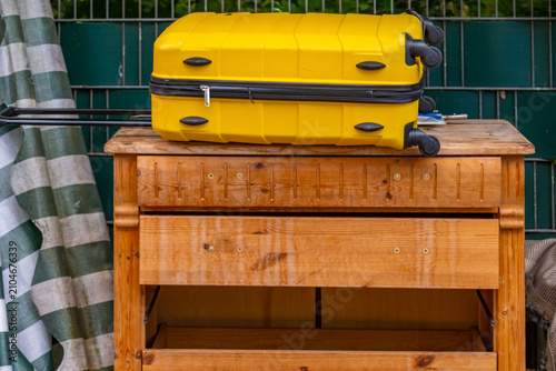 Bild auf Leinwand bulky waste reduction, large yellow suitcase, waste bins ending vacation moving