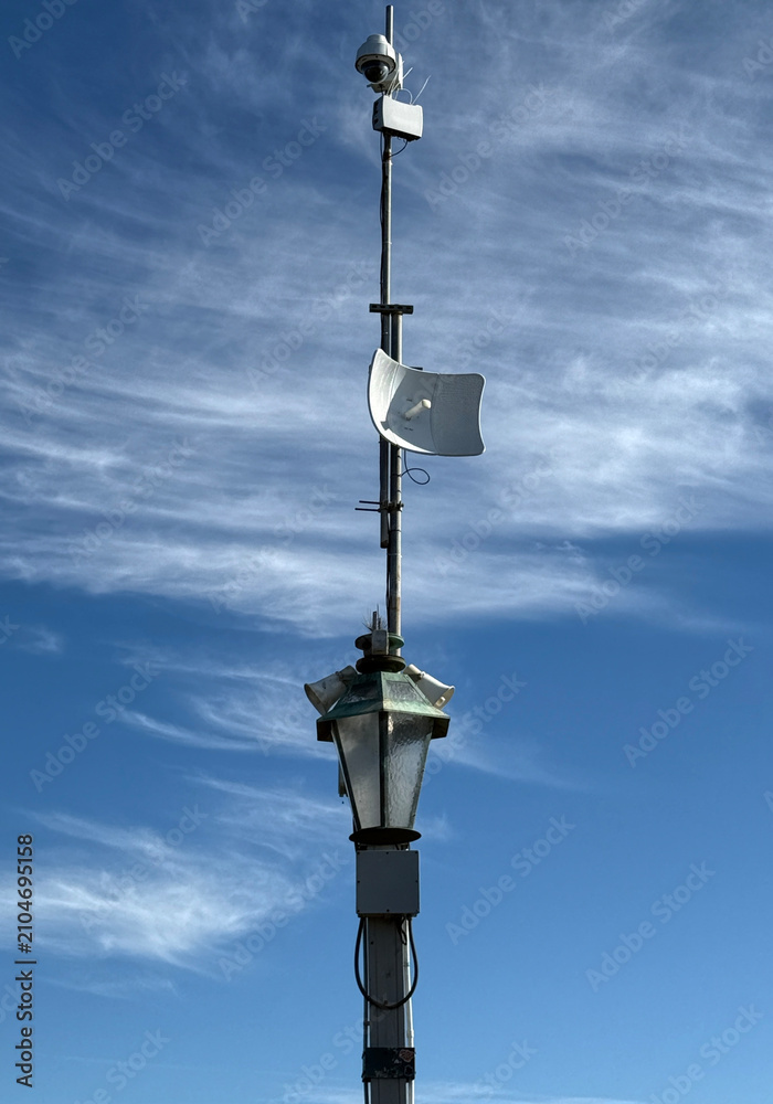 Fototapeta premium Security camera and antenna on top of a lamp on an ocean pier