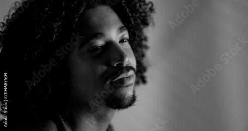 Cuadro en lienzo Young man with curly hair and beard looking away in a contemplative moment