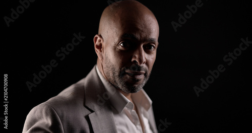 Konstfotografi Confident bald man in a suit jacket posing against a dark background, showing se