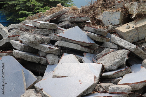 Stacked broken concrete blocks and slabs from demolished structure ready for disposal process