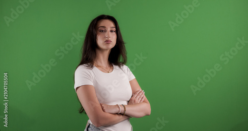Canvastavla Young woman standing with arms crossed, expressing seriousness and confidence on