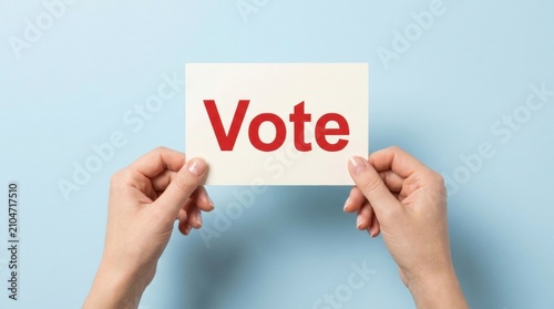 Female hands holding white card with red vote text against light blue background with voting text participation communication