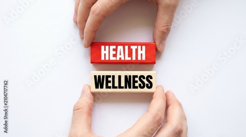 Hands arranging wooden blocks with health and wellness text on white surface with positioning wooden white background conceptual