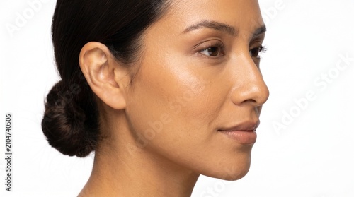 Close-up profile of a woman's face with clear, glowing skin and dark hair pulled back